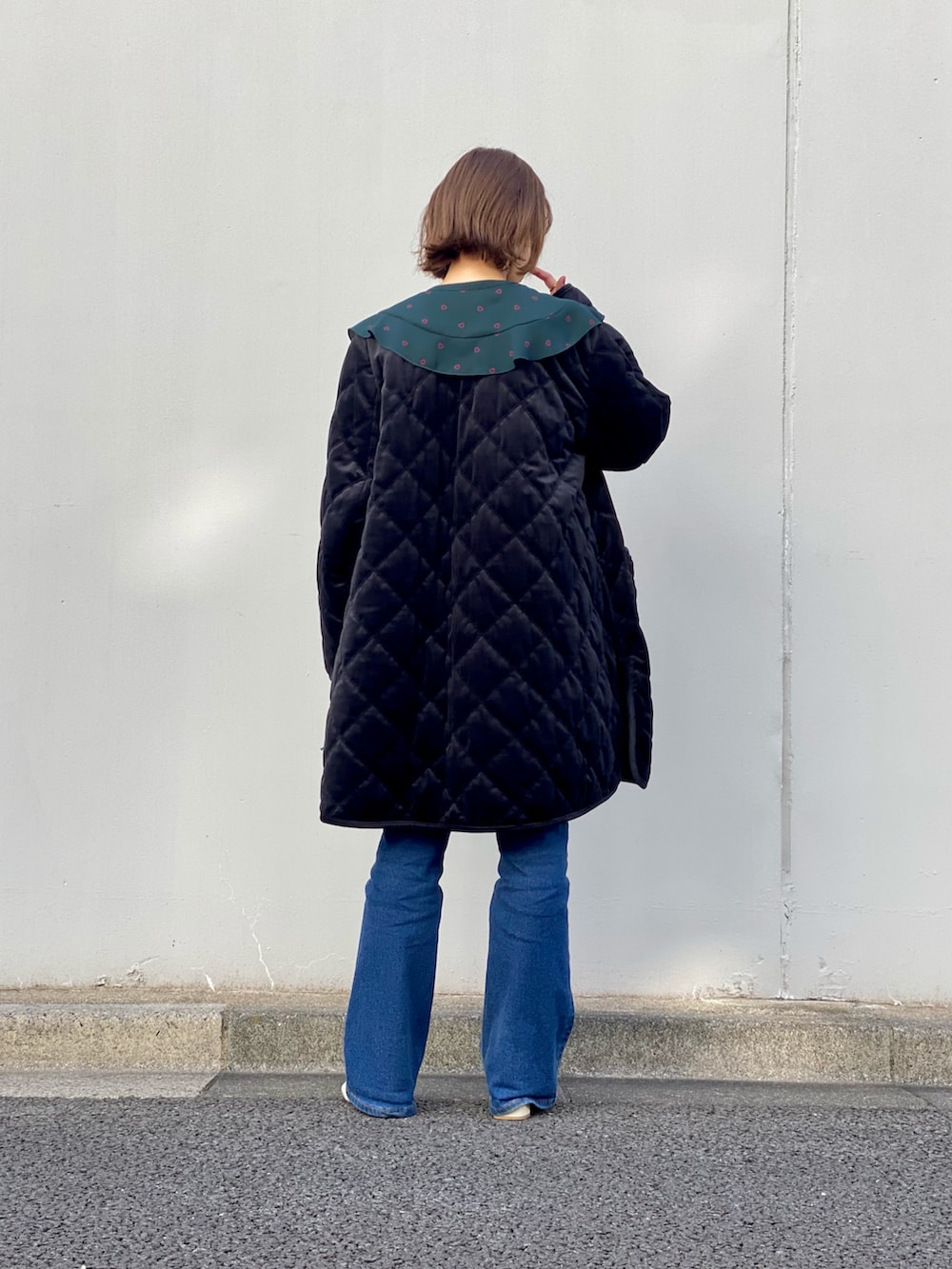 グリーン系のシャツ/ブラウス、ブラック系のブルゾン、ブルー系のデニムパンツを着用したレディースの冬コーディネートの3枚目の写真