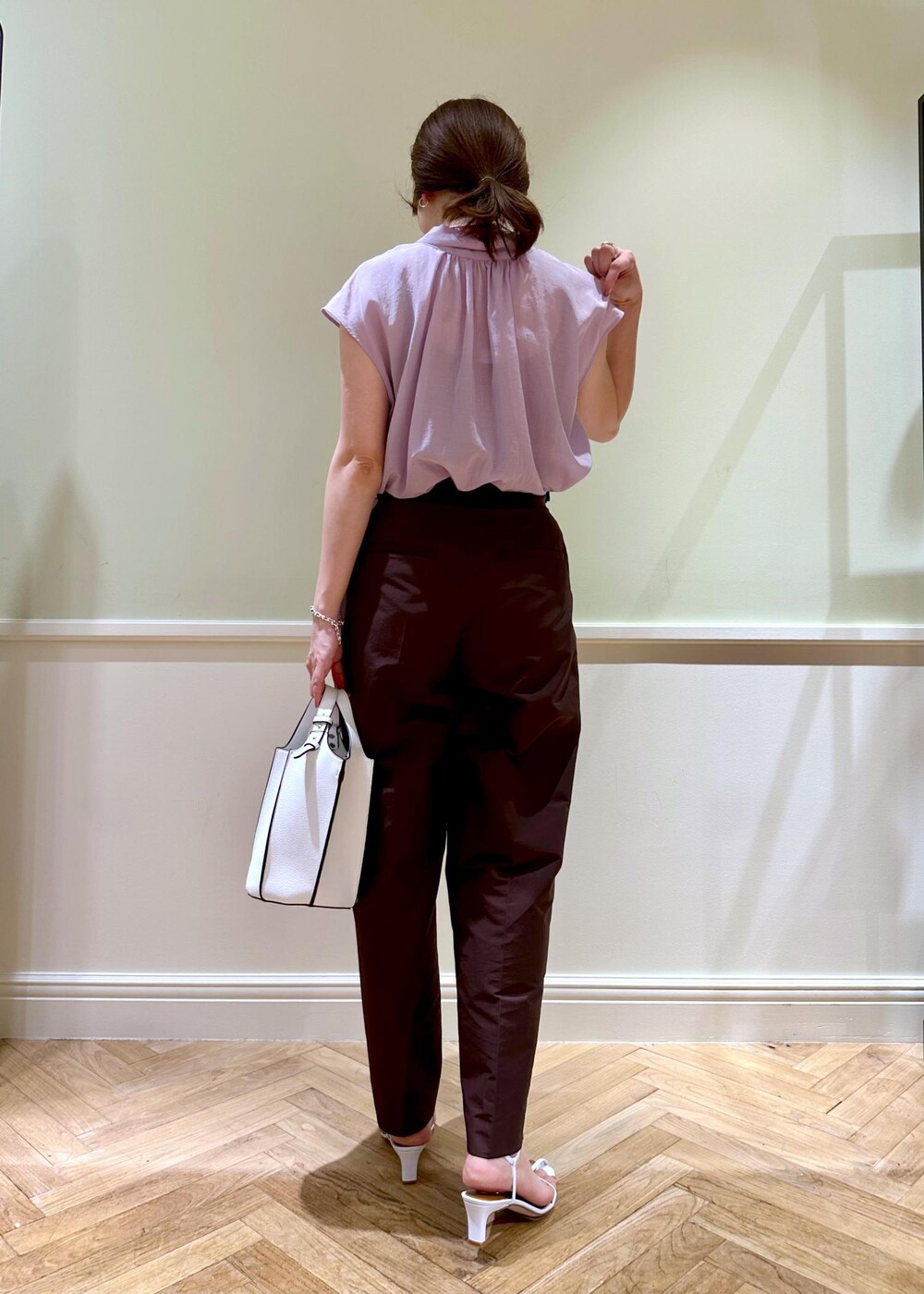 ホワイト系のハンドバッグ、パープル系のシャツ/ブラウス、ホワイト系のサンダルを着用したレディースの夏コーディネートの3枚目の写真