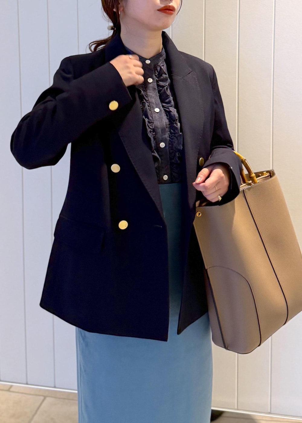 ベージュ系のトートバッグ、ブルー系のスカート、ブルー系のテーラードジャケットを着用したレディースの秋コーディネートの5枚目の写真
