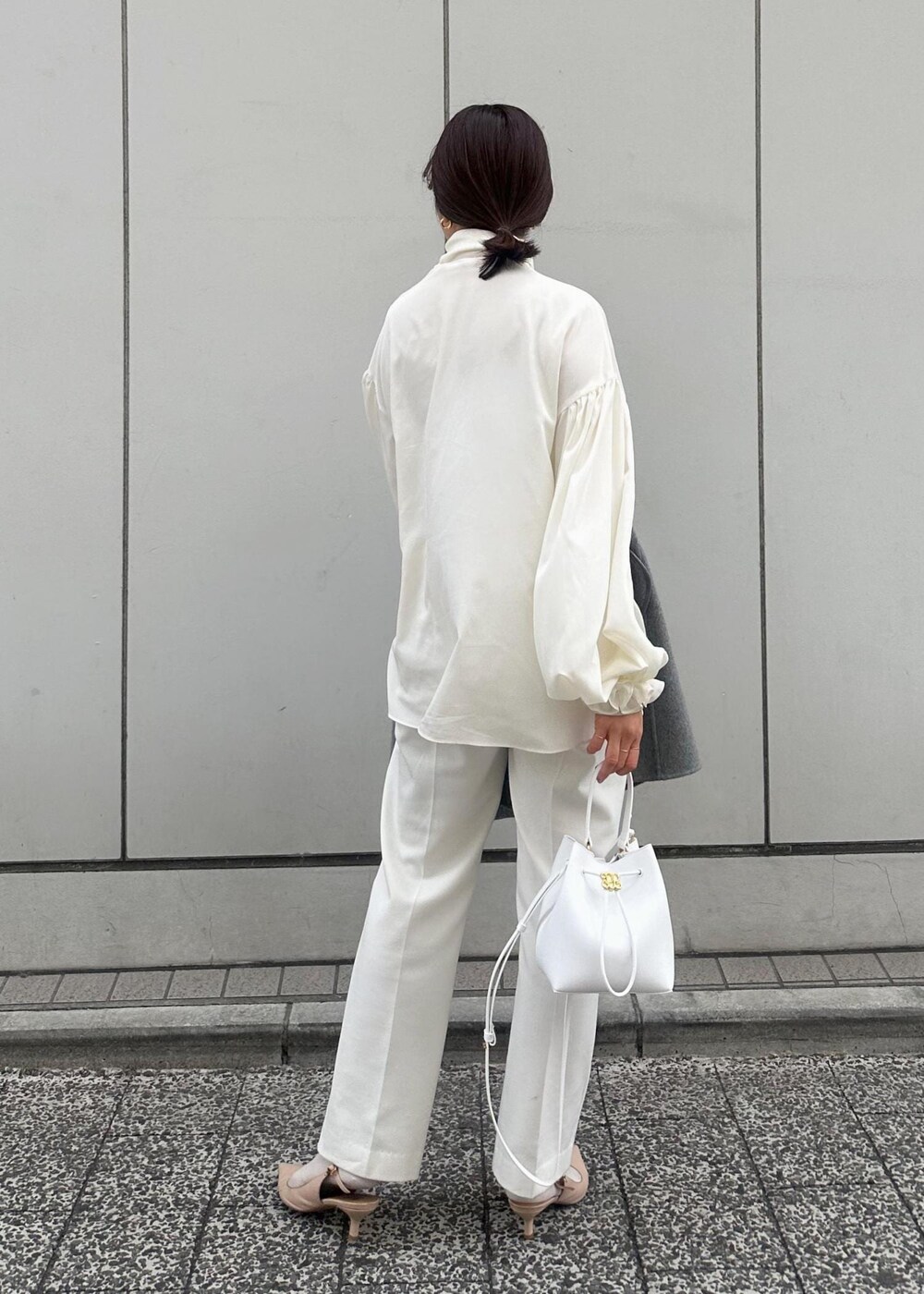 グレー系のその他アウター、ベージュ系のパンプス、ホワイト系のハンドバッグを着用したレディースの冬コーディネートの3枚目の写真