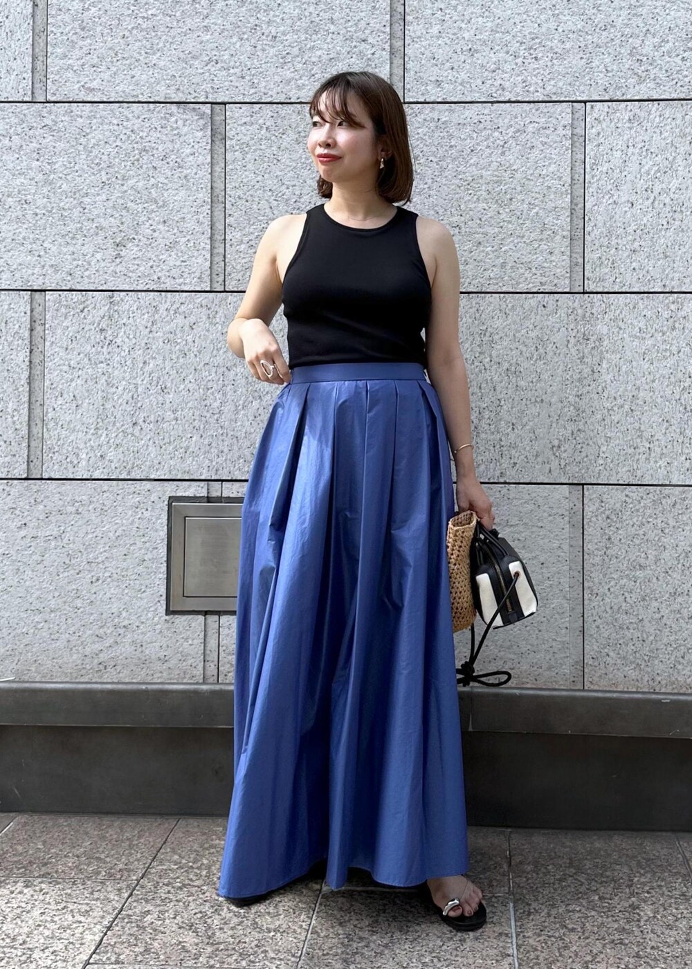 ブラック系のサンダル、ブルー系のスカート、ブラック系のタンクトップを着用したレディースの夏コーディネートの2枚目の写真