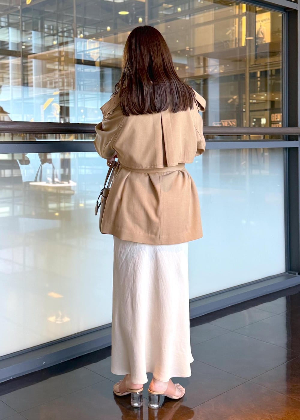 ベージュ系のトレンチコート、ベージュ系のスカート、ベージュ系のシャツ/ブラウスを着用したレディースの春コーディネートの3枚目の写真