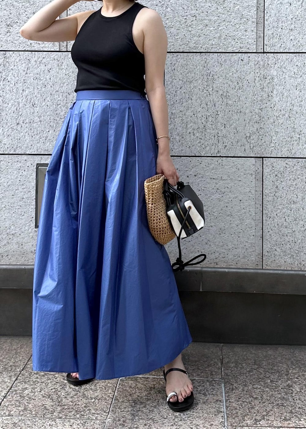 ブラック系のサンダル、ブルー系のスカート、ブラック系のタンクトップを着用したレディースの夏コーディネートの8枚目の写真