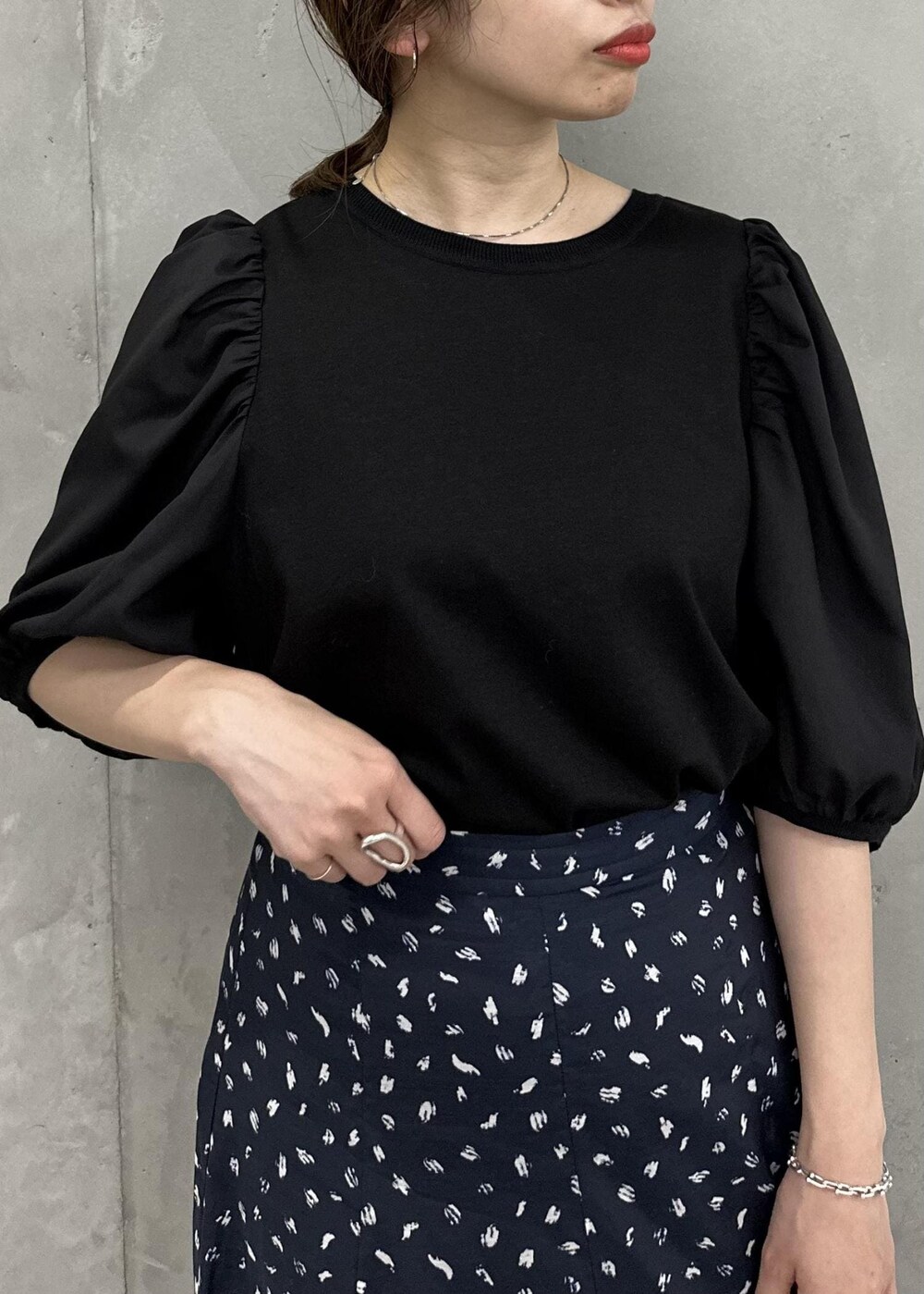 ブラック系のスカート、ホワイト系のハンドバッグ、ホワイト系のサンダルを着用したレディースの春コーディネートの4枚目の写真