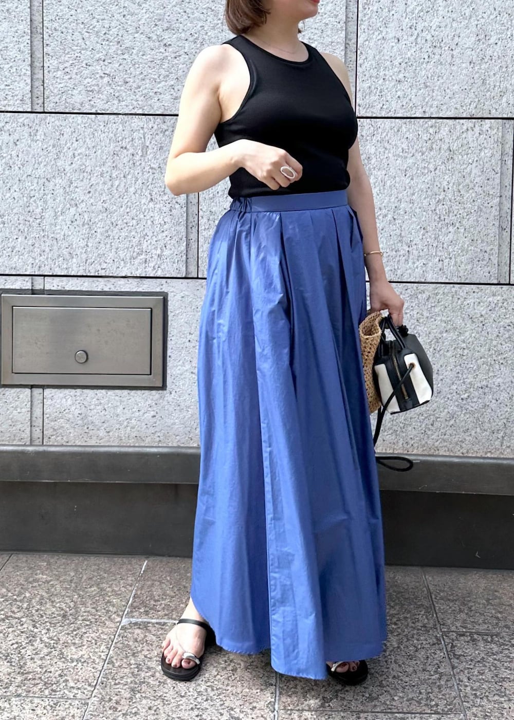 ブラック系のサンダル、ブルー系のスカート、ブラック系のタンクトップを着用したレディースの夏コーディネートの7枚目の写真