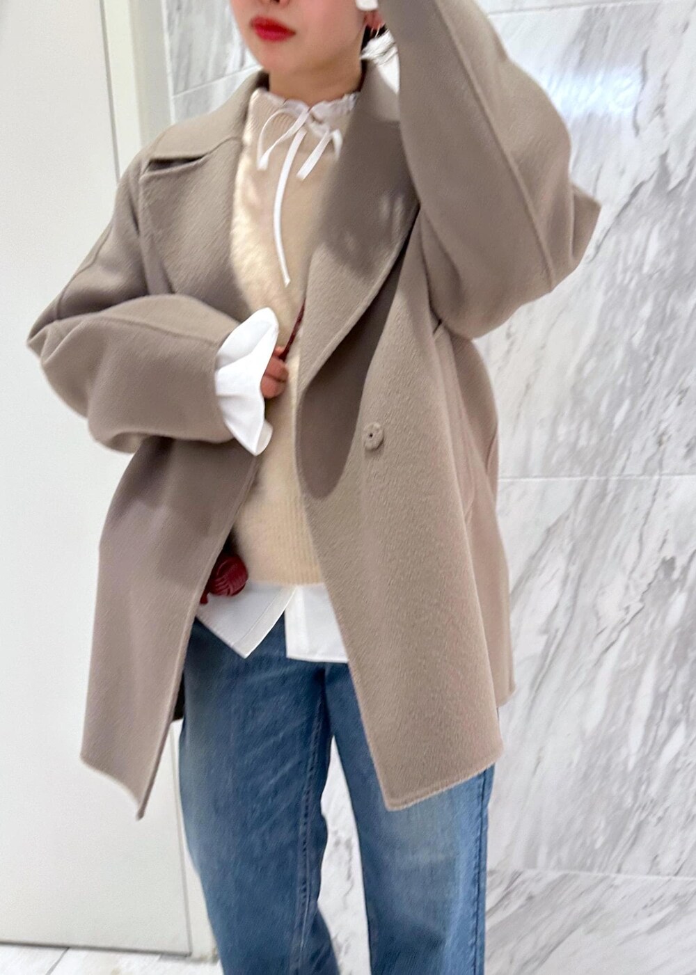 レッド系のパンプス、ベージュ系のニット/セーター、ベージュ系のピーコートを着用したレディースの冬コーディネートの9枚目の写真