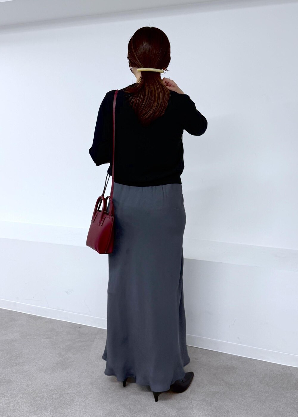 グレー系のスカート、ブラック系のシャツ/ブラウス、レッド系のショルダーバッグを着用したレディースの夏コーディネートの3枚目の写真