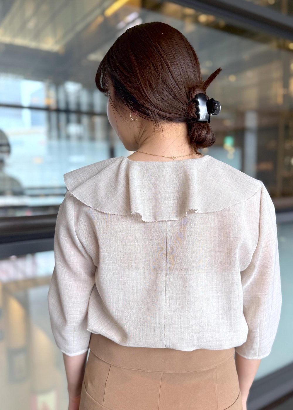 ブラック系のハンドバッグ、ベージュ系のシャツ/ブラウス、ブラウン系のその他パンツを着用したレディースの春コーディネートの7枚目の写真