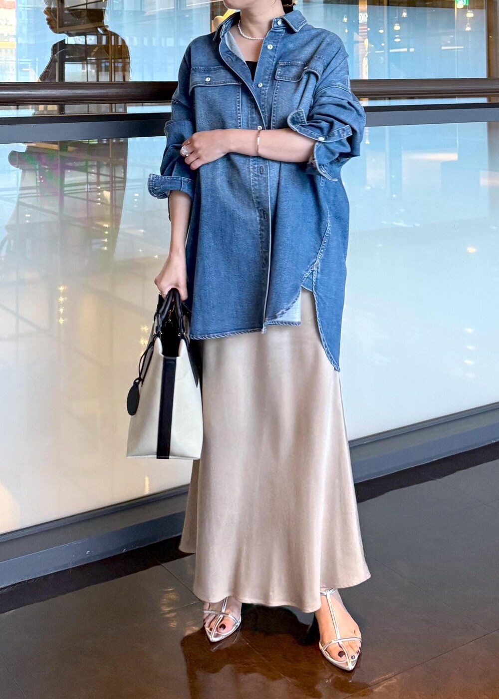 ベージュ系のスカート、ブルー系のシャツ/ブラウス、ホワイト系のトートバッグを着用したレディースの夏コーディネートの4枚目の写真
