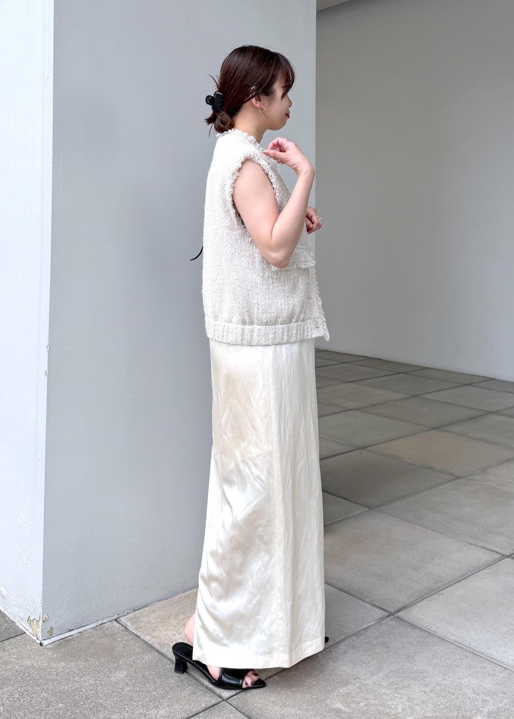 ホワイト系のスカート、ホワイト系のベストを着用したレディースの夏コーディネートの3枚目の写真