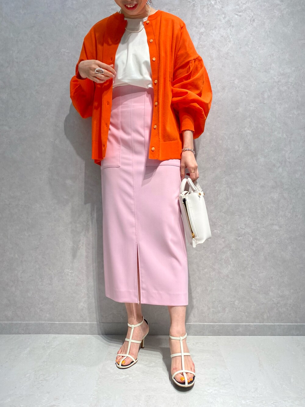 ホワイト系のショルダーバッグ、ホワイト系のサンダル、ピンク系のスカートを着用したレディースの春コーディネートの5枚目の写真