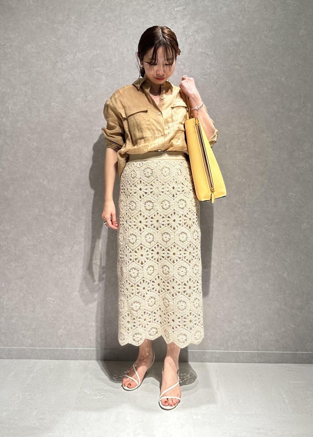 ベージュ系のシャツ/ブラウス、ホワイト系のスカート、イエロー系のバッグを着用したレディースの春コーディネートの7枚目の写真