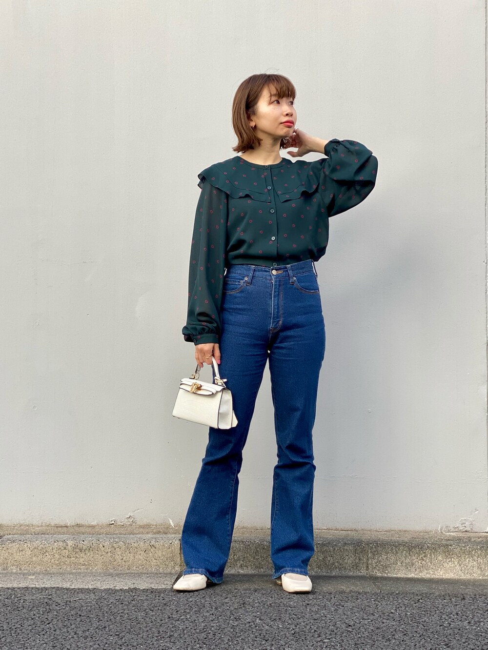 グリーン系のシャツ/ブラウス、ブルー系のデニムパンツ、ホワイト系のパンプスを着用したレディースの冬コーディネートの2枚目の写真