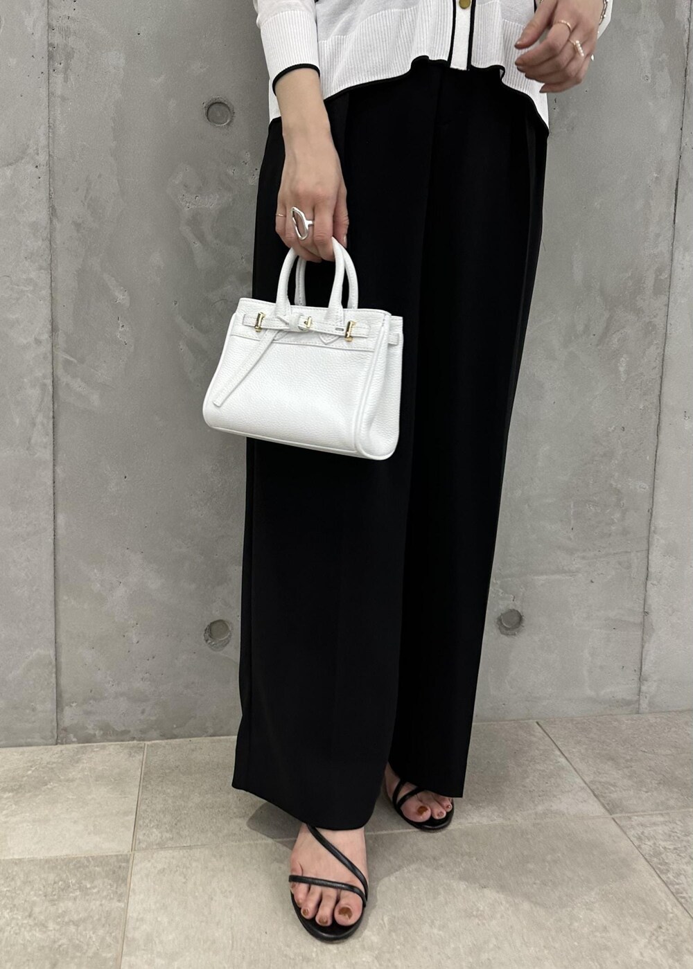 ブラック系のその他パンツ、ホワイト系のカーディガン/ボレロ、ブラック系のサンダルを着用したレディースの春コーディネートの5枚目の写真