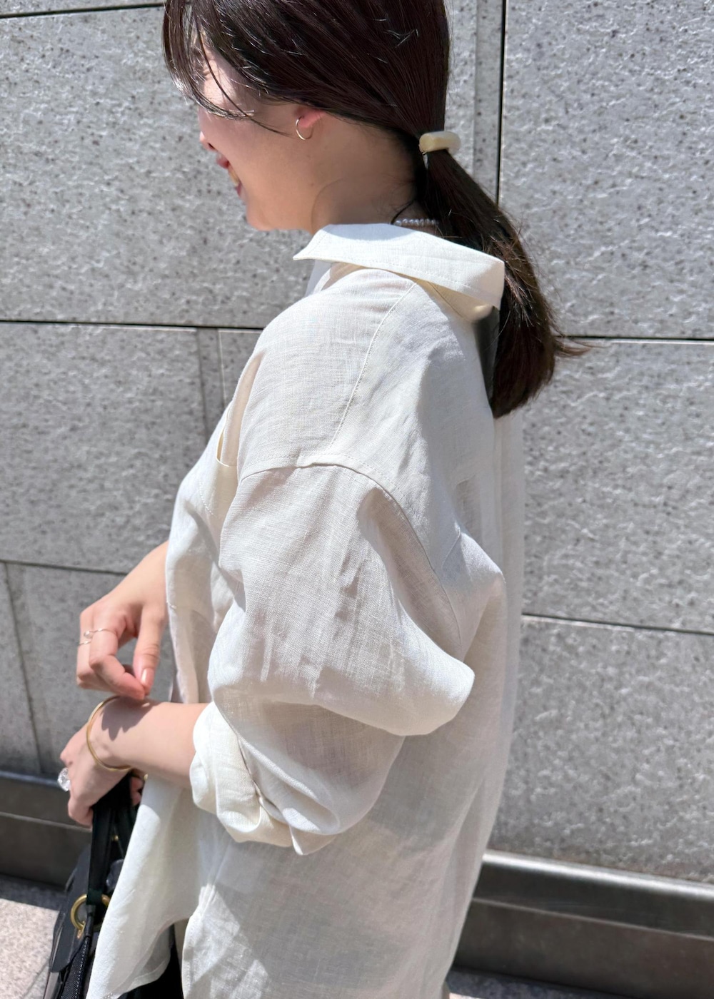 ブラック系のハンドバッグ、ベージュ系のスカート、ホワイト系のシャツ/ブラウスを着用したレディースの夏コーディネートの5枚目の写真