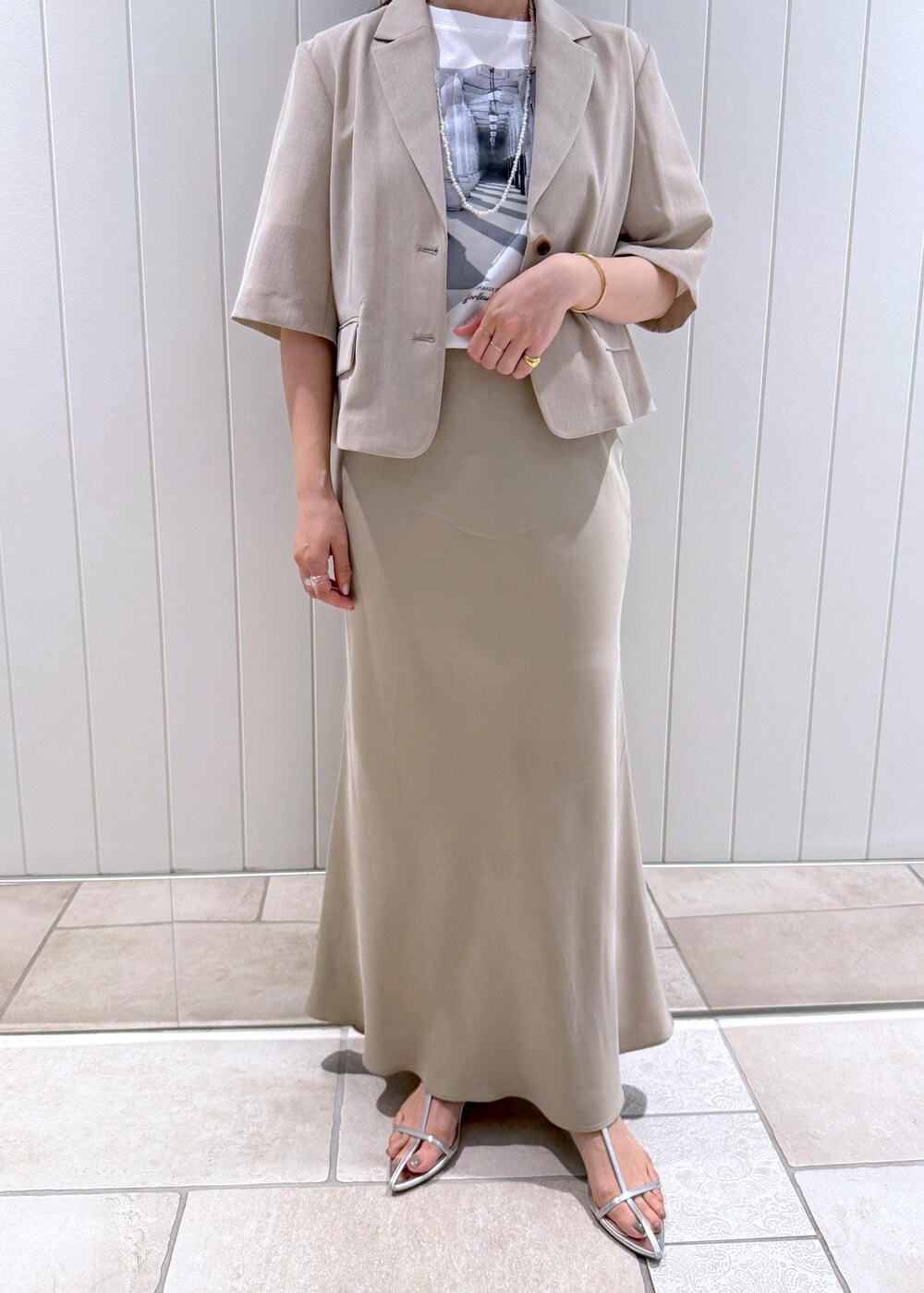 ベージュ系のトートバッグ、ホワイト系のTシャツ/カットソー、ベージュ系のスカートを着用したレディースの春コーディネートの8枚目の写真