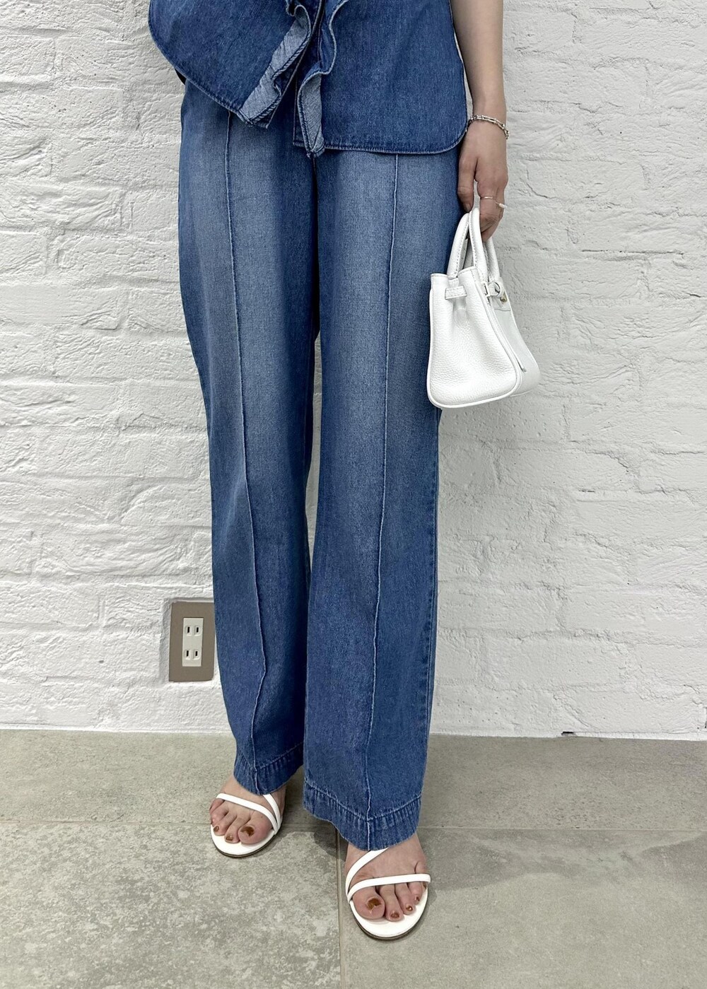 ブルー系のシャツ/ブラウス、ホワイト系のサンダル、ブルー系のデニムパンツを着用したレディースの春コーディネートの6枚目の写真