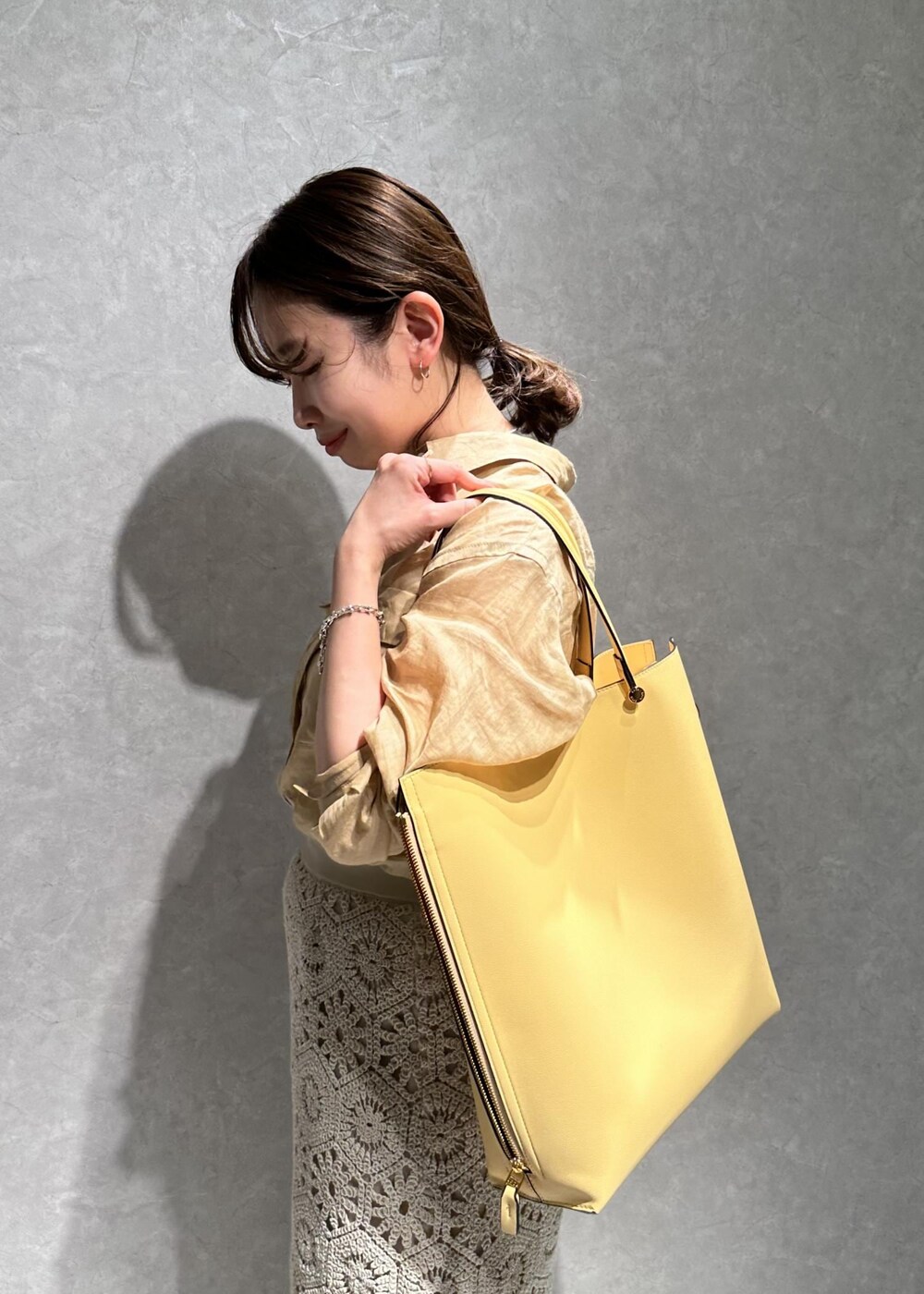 ベージュ系のシャツ/ブラウス、ホワイト系のスカート、イエロー系のバッグを着用したレディースの春コーディネートの6枚目の写真