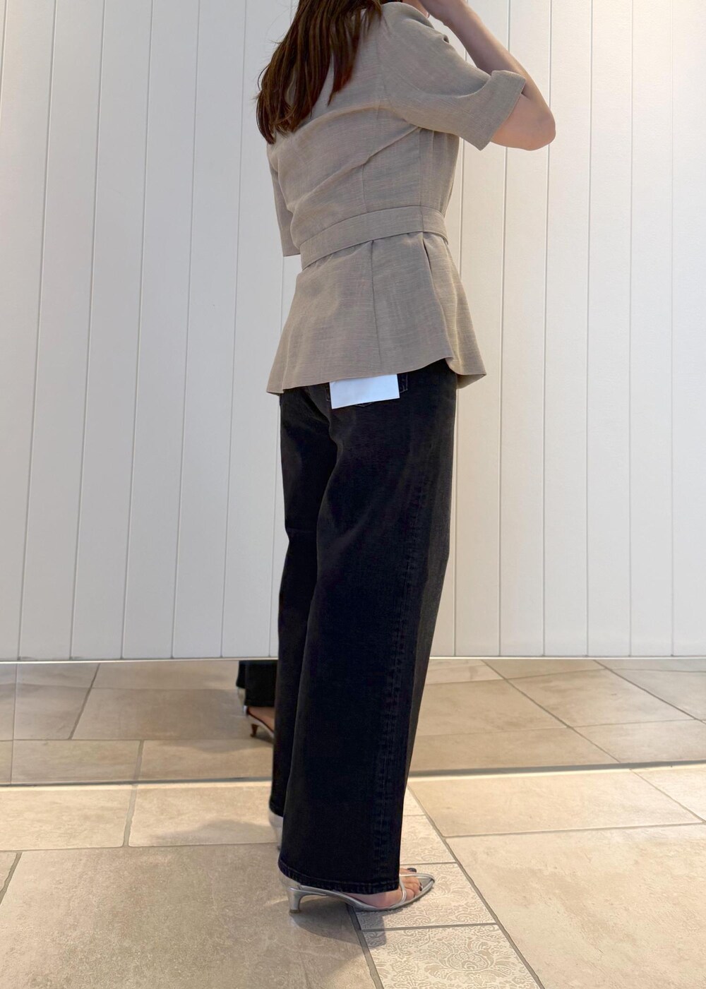 ベージュ系のテーラードジャケット、ブラック系のデニムパンツ、ホワイト系のショルダーバッグを着用したレディースの夏コーディネートの5枚目の写真