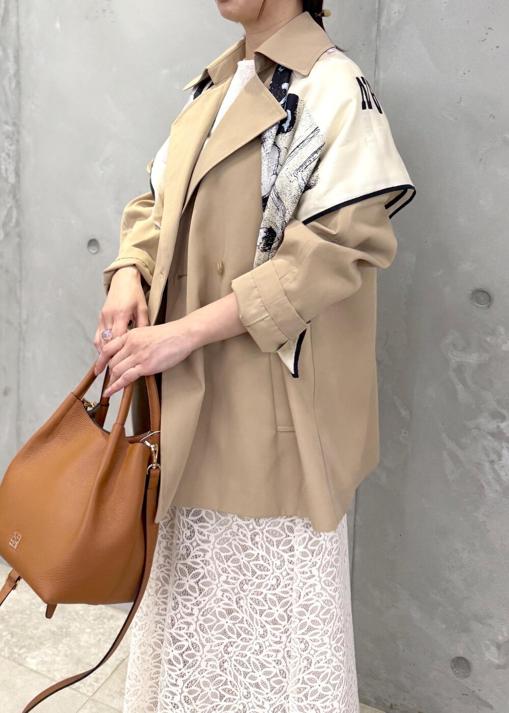 ホワイト系のTシャツ/カットソー、ベージュ系のトレンチコート、イエロー系のハンドバッグを着用したレディースの春コーディネートの5枚目の写真