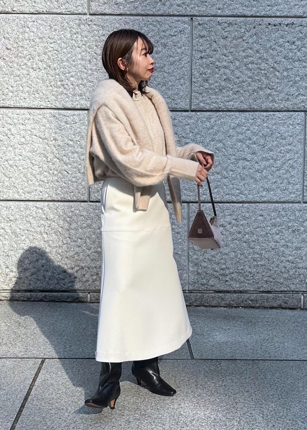 ホワイト系のスカート、ベージュ系のカーディガン/ボレロ、ベージュ系のニット/セーターを着用したレディースの秋コーディネートの3枚目の写真