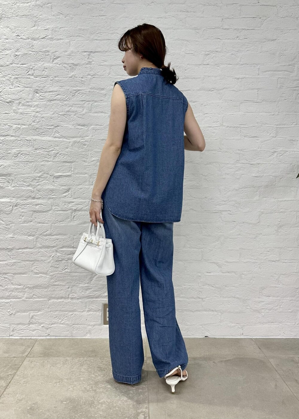 ブルー系のシャツ/ブラウス、ホワイト系のサンダル、ブルー系のデニムパンツを着用したレディースの春コーディネートの3枚目の写真