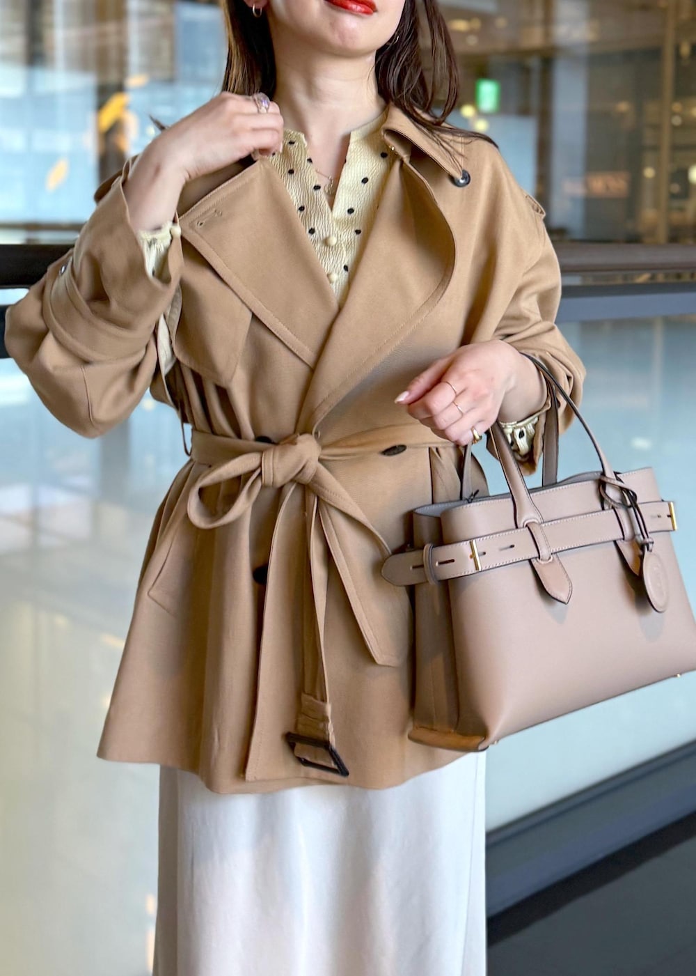 ベージュ系のトレンチコート、ベージュ系のスカート、ベージュ系のシャツ/ブラウスを着用したレディースの春コーディネートの4枚目の写真
