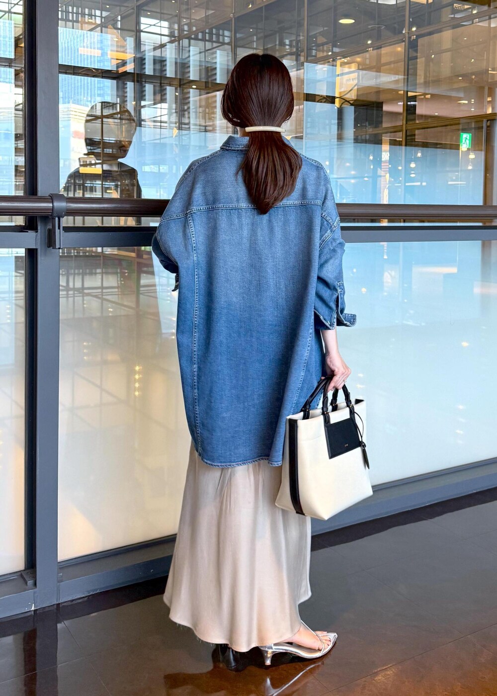 ベージュ系のスカート、ブルー系のシャツ/ブラウス、ホワイト系のトートバッグを着用したレディースの夏コーディネートの3枚目の写真