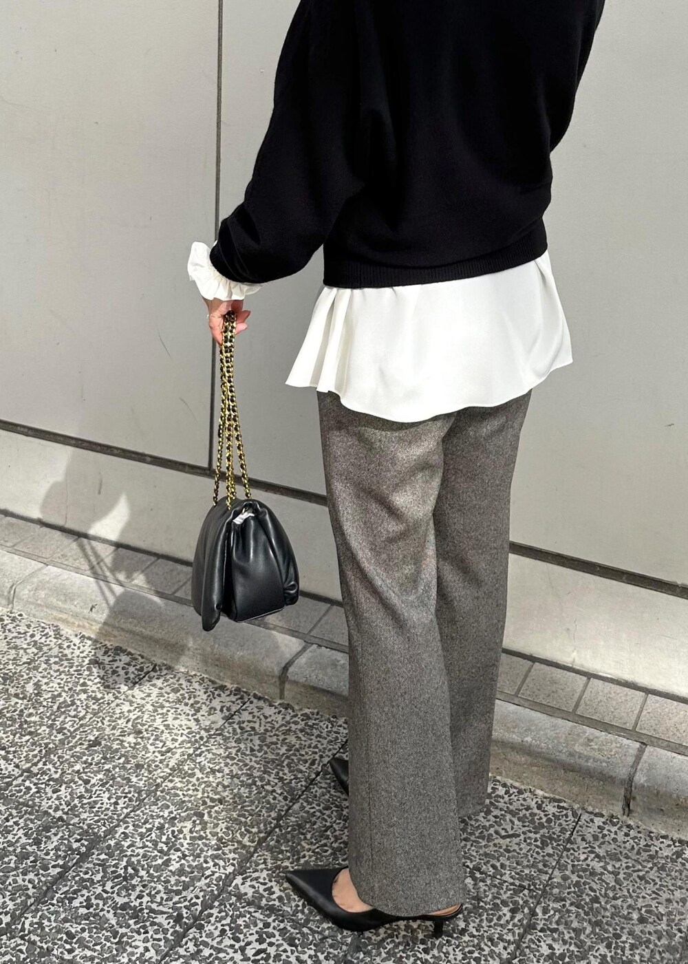 ブラック系のハンドバッグ、ブラック系のパンプス、グレー系のその他パンツを着用したレディースの秋コーディネートの8枚目の写真