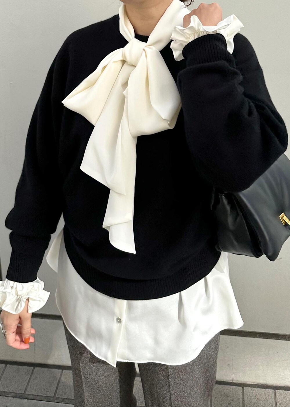 ブラック系のハンドバッグ、ブラック系のパンプス、グレー系のその他パンツを着用したレディースの秋コーディネートの6枚目の写真