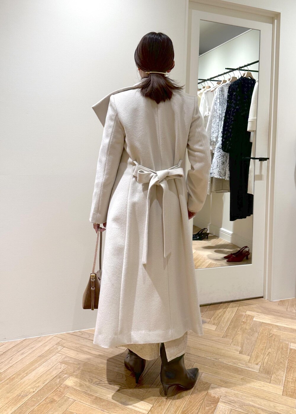 ブラック系のブーツ、ベージュ系のスカート、ベージュ系のニット/セーターを着用したレディースの冬コーディネートの7枚目の写真