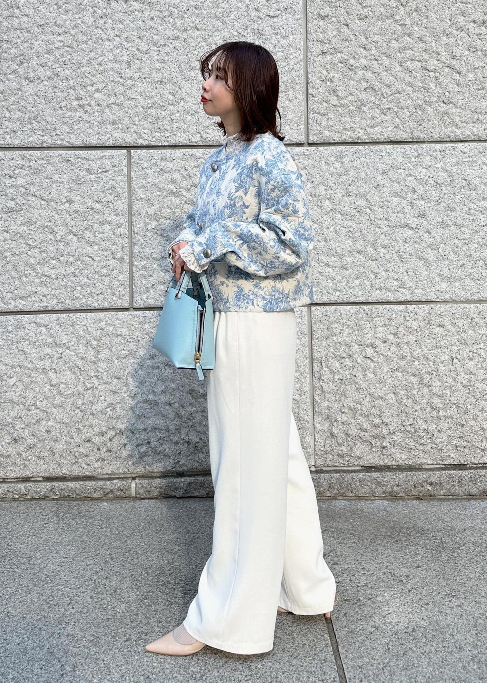 ブルー系のハンドバッグ、ベージュ系のパンプス、ホワイト系のその他パンツを着用したレディースの冬コーディネートの3枚目の写真