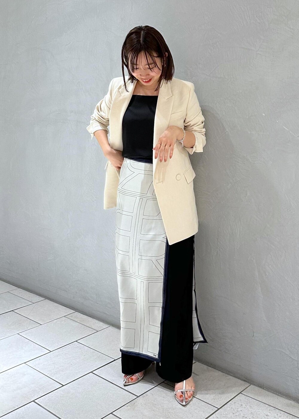 ブラック系のキャミソール、ホワイト系のテーラードジャケット、ホワイト系のバンダナ/スカーフを着用したレディースの冬コーディネートの2枚目の写真