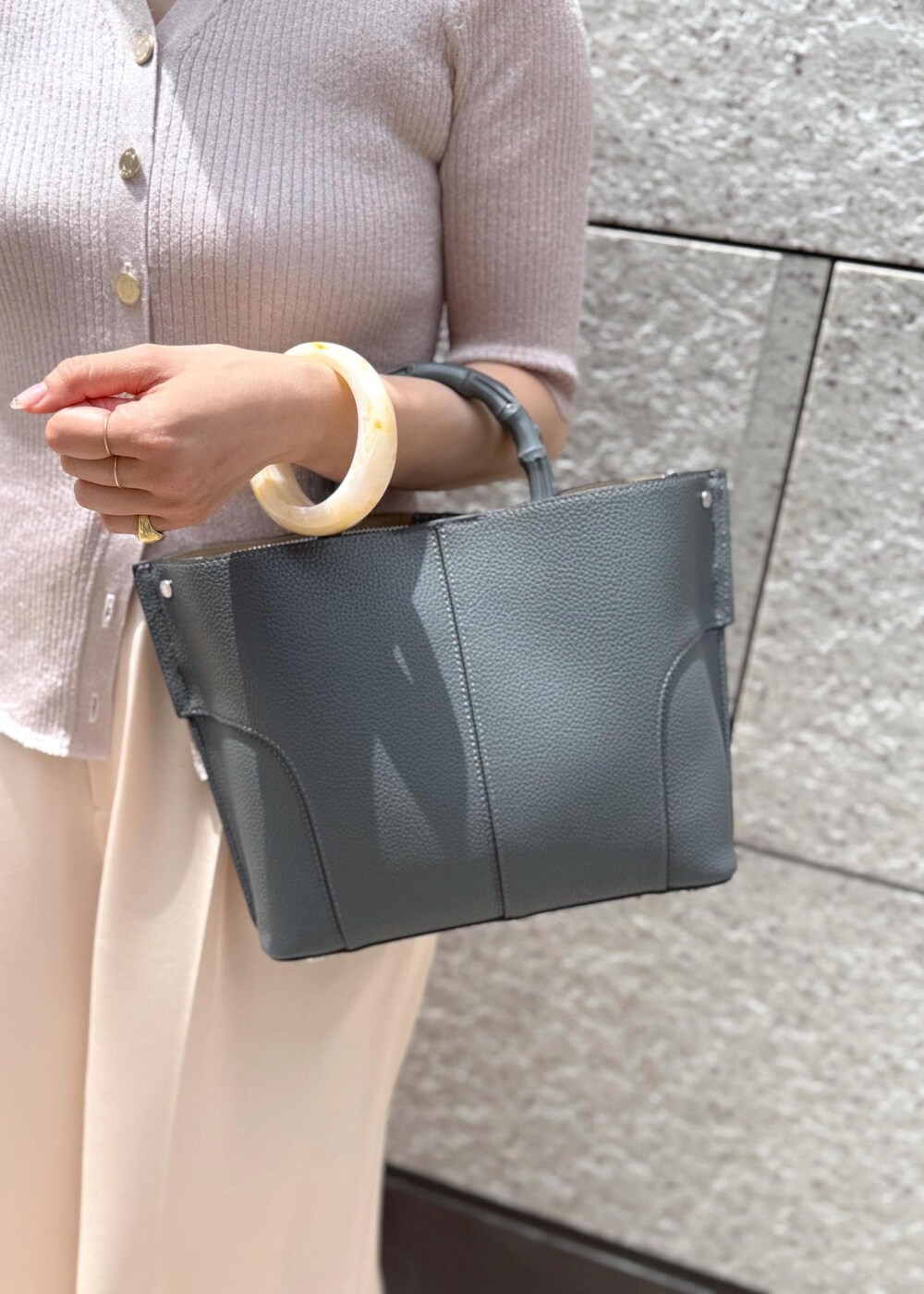 ピンク系のその他パンツ、ピンク系のカーディガン/ボレロ、グレー系のハンドバッグを着用したレディースの夏コーディネートの5枚目の写真