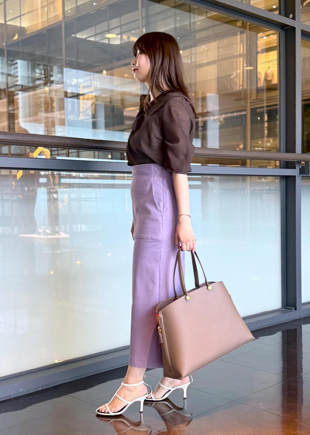 ブラウン系のトートバッグ、パープル系のスカート、ブラウン系のシャツ/ブラウスを着用したレディースの春コーディネートの4枚目の写真