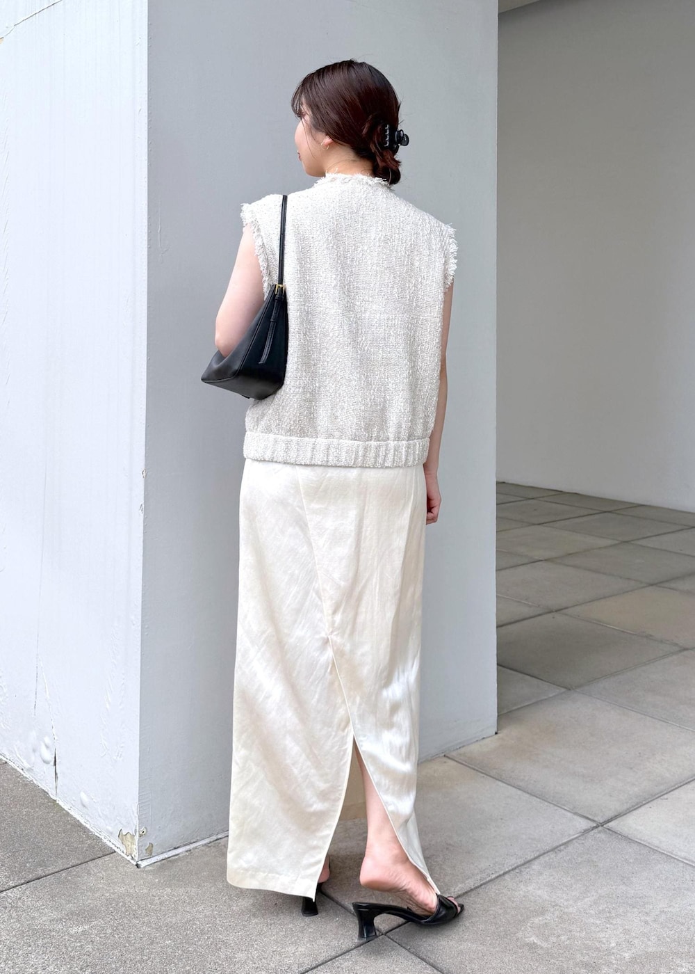 ホワイト系のスカート、ホワイト系のベストを着用したレディースの夏コーディネートの4枚目の写真