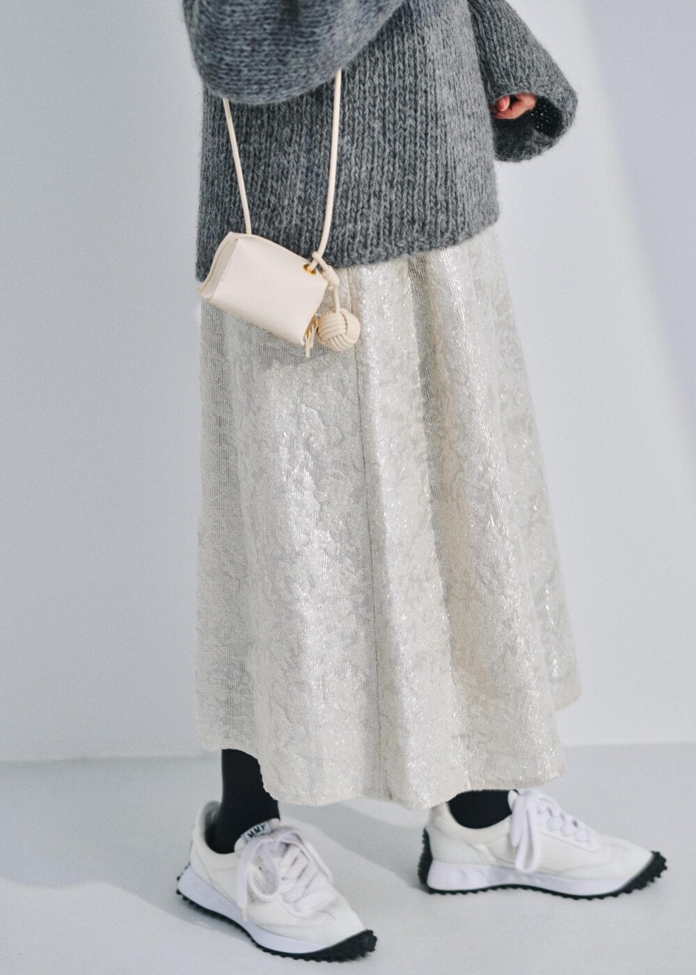 ホワイト系のショルダーバッグ、グレー系のニット/セーター、ホワイト系のワンピースを着用したレディースの冬コーディネートの5枚目の写真