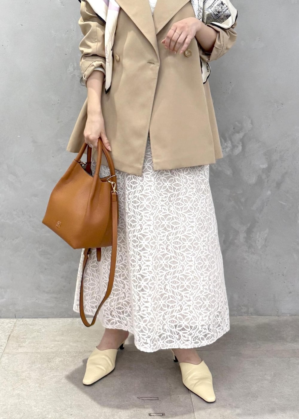 ホワイト系のTシャツ/カットソー、ベージュ系のトレンチコート、イエロー系のハンドバッグを着用したレディースの春コーディネートの7枚目の写真