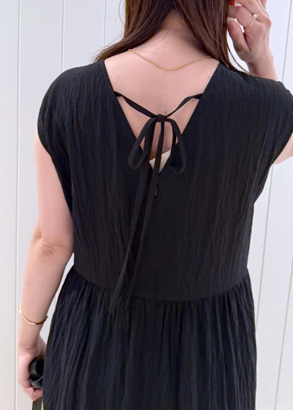 ブラック系のワンピース、ゴールド系のネックレスを着用したレディースの夏コーディネートの7枚目の写真