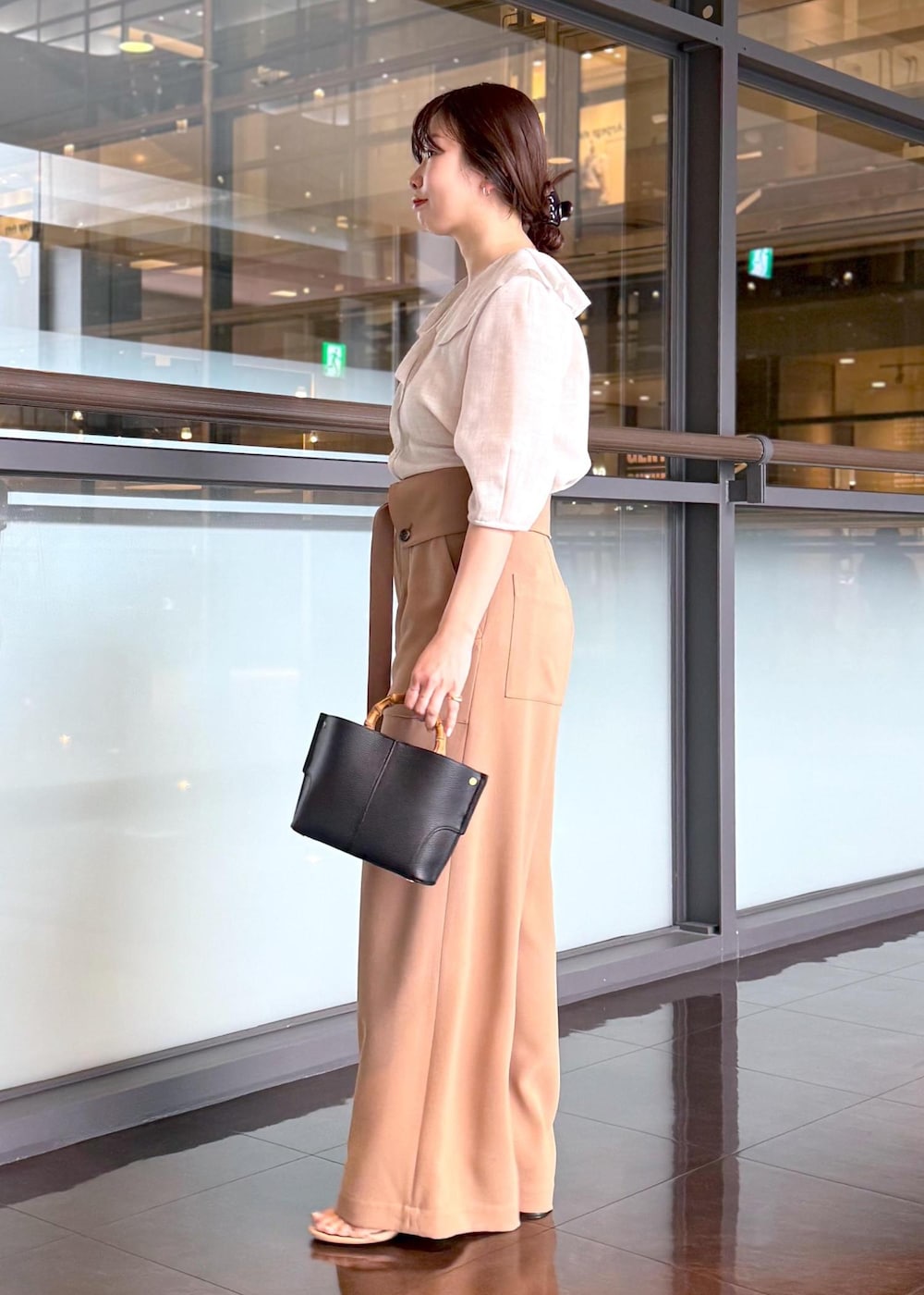 ブラック系のハンドバッグ、ベージュ系のシャツ/ブラウス、ブラウン系のその他パンツを着用したレディースの春コーディネートの3枚目の写真