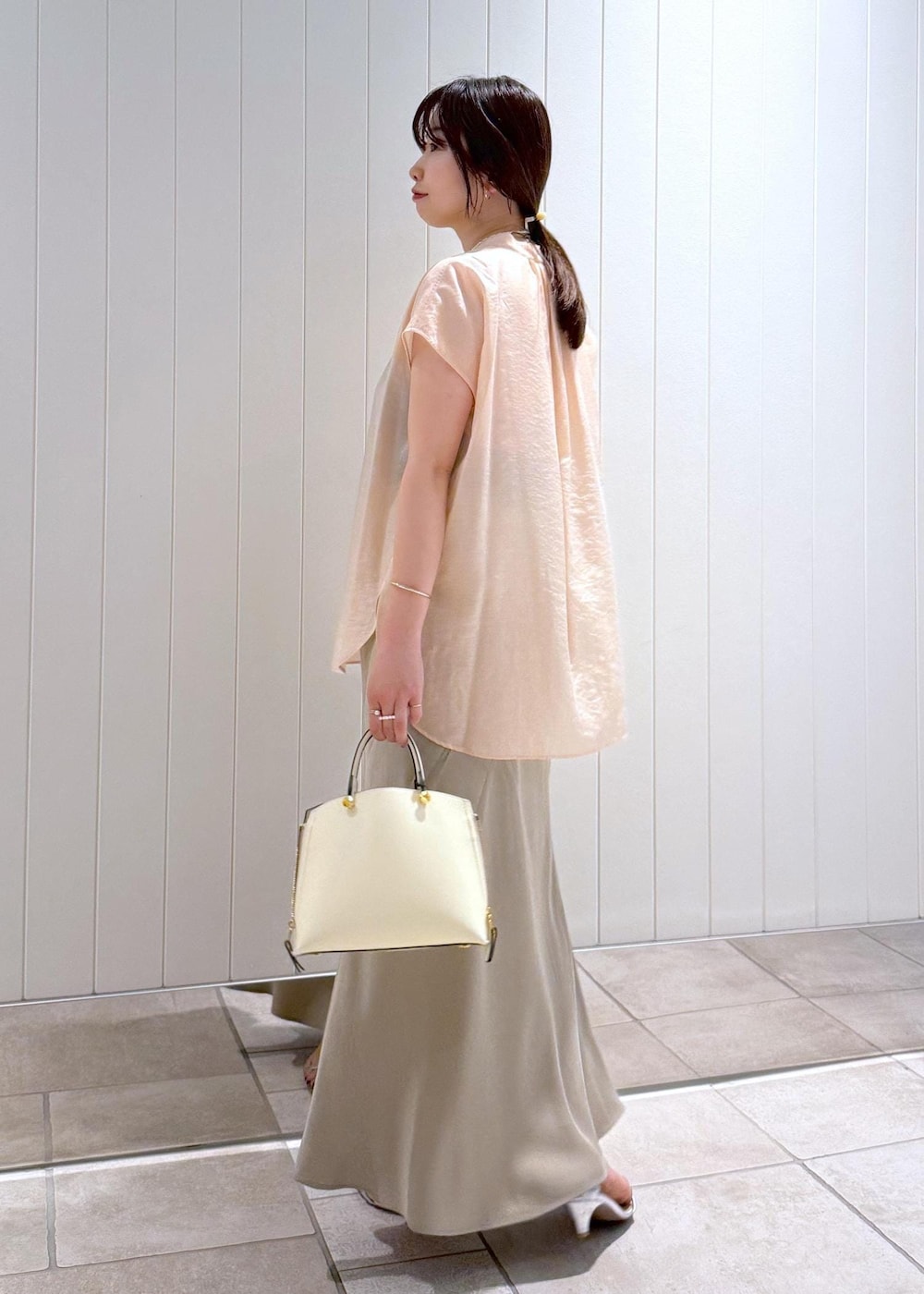 ベージュ系のスカート、ピンク系のシャツ/ブラウス、ホワイト系のハンドバッグを着用したレディースの夏コーディネートの3枚目の写真