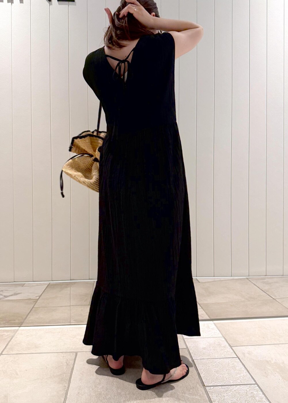 ブラック系のワンピース、ゴールド系のネックレスを着用したレディースの夏コーディネートの5枚目の写真