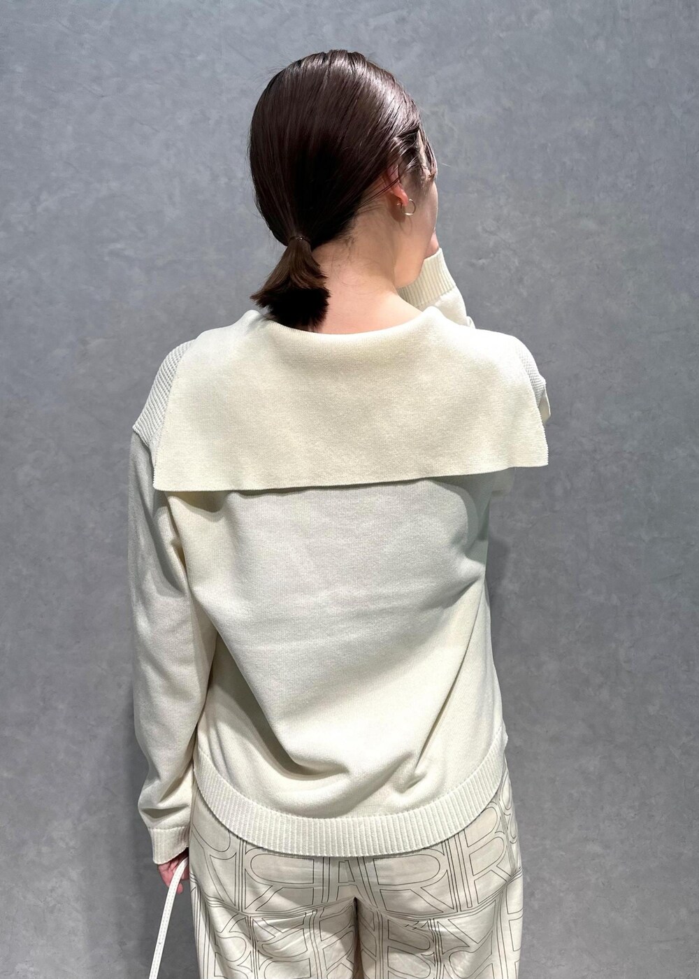 ホワイト系のニット/セーター、ホワイト系のその他パンツ、ホワイト系のハンドバッグを着用したレディースの春コーディネートの6枚目の写真