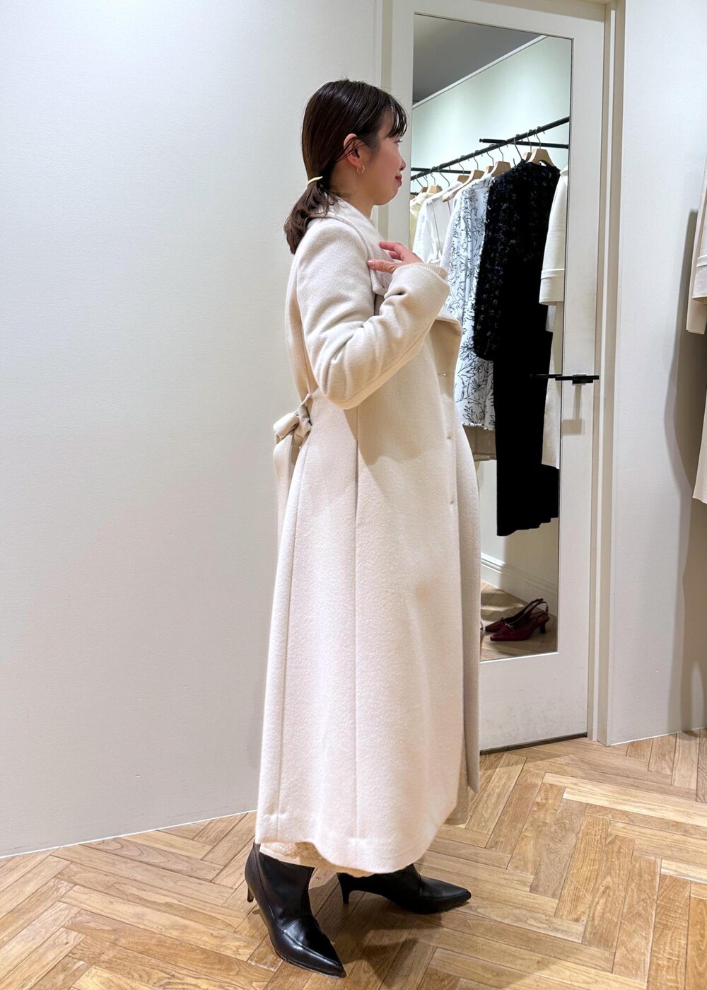 ブラック系のブーツ、ベージュ系のスカート、ベージュ系のニット/セーターを着用したレディースの冬コーディネートの6枚目の写真