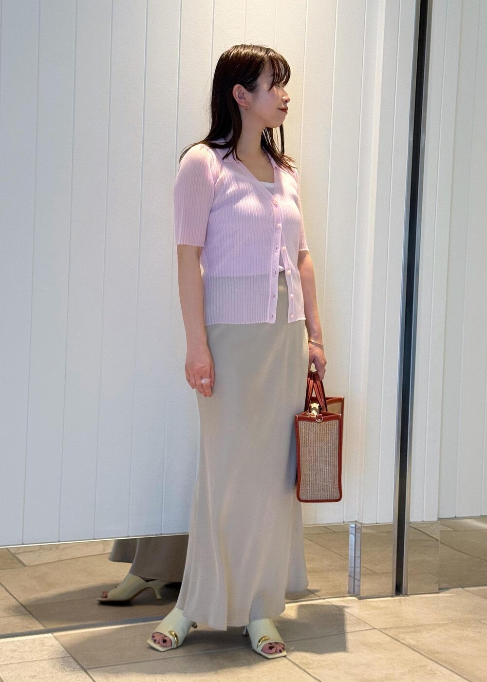 ベージュ系のサンダル、ベージュ系のスカート、ピンク系のキャミソールを着用したレディースの春コーディネートの2枚目の写真