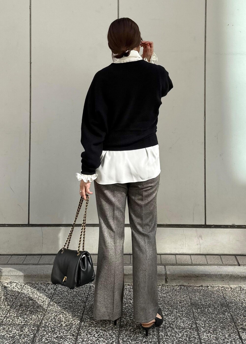 ブラック系のハンドバッグ、ブラック系のパンプス、グレー系のその他パンツを着用したレディースの秋コーディネートの2枚目の写真