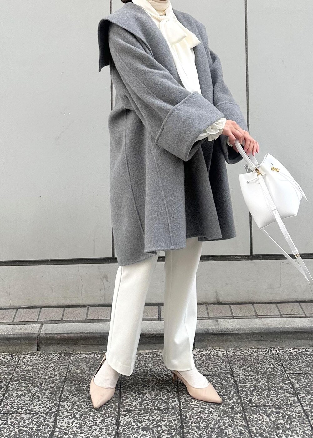 グレー系のその他アウター、ベージュ系のパンプス、ホワイト系のハンドバッグを着用したレディースの冬コーディネートの5枚目の写真