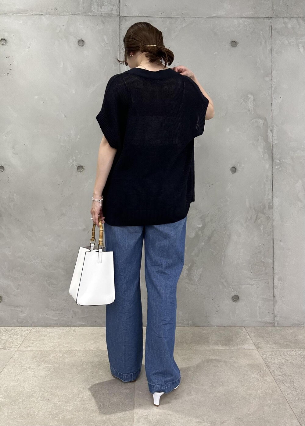 ブルー系のベスト、ブルー系のデニムパンツ、ホワイト系のサンダルを着用したレディースの春コーディネートの3枚目の写真