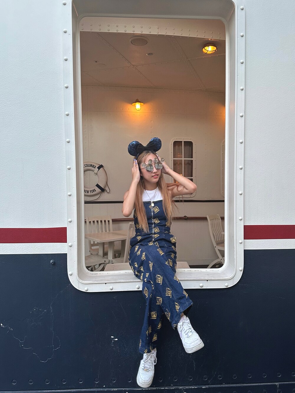 ブルー系のサロペット/オーバーオール、ベージュ系のショルダーバッグ、ホワイト系のスニーカーを着用したレディースの冬コーディネートの2枚目の写真