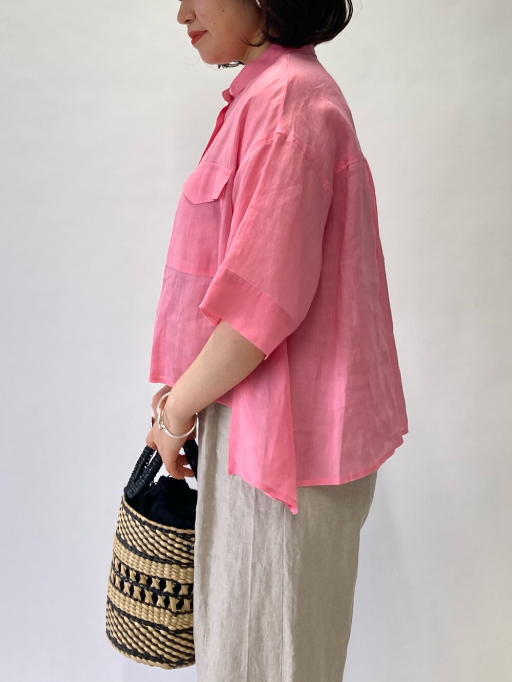 ピンク系のシャツ/ブラウス、ベージュ系のかごバッグ、ベージュ系のサンダルを着用したレディースの春コーディネートの4枚目の写真